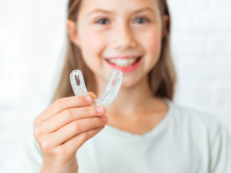 Attractive little girl shows myofunctional trainer. Help equalize the growing teeth