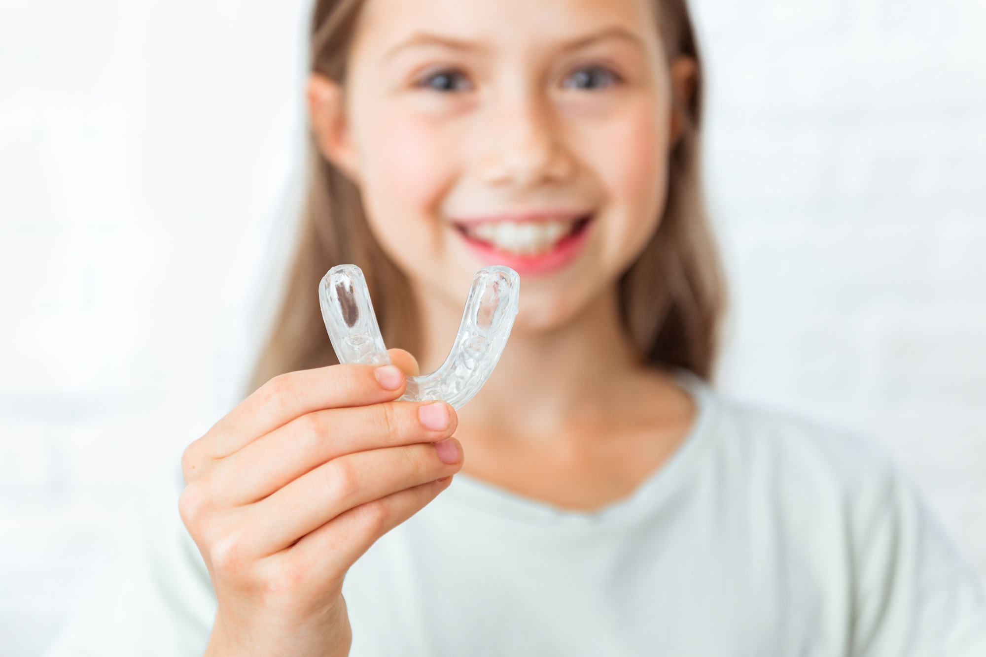 Attractive little girl shows myofunctional trainer. Help equalize the growing teeth